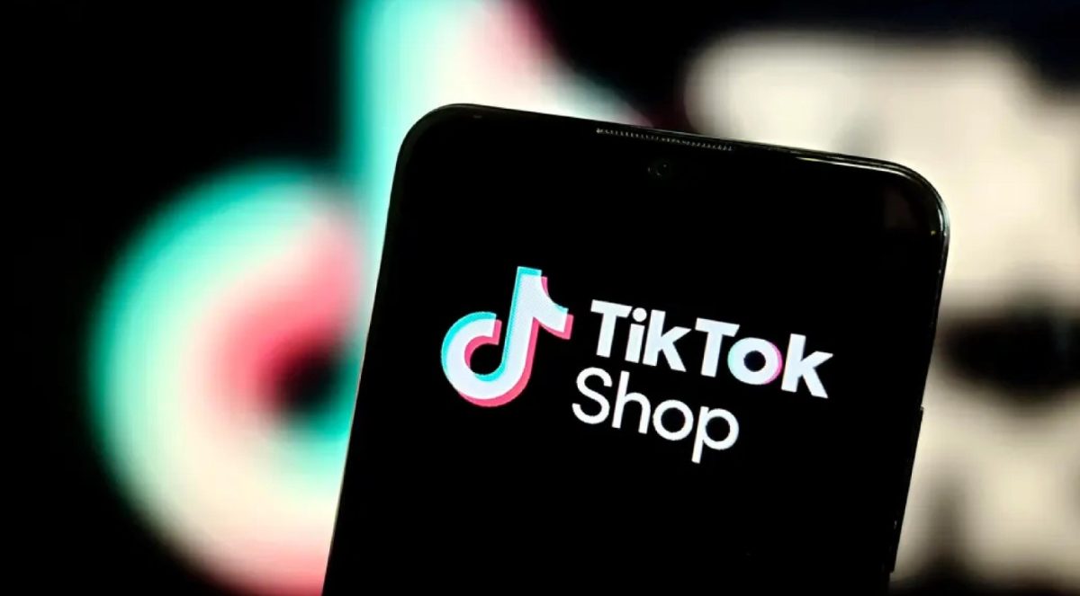 A phone open to TikTok Shop, held in front of the TikTok logo.